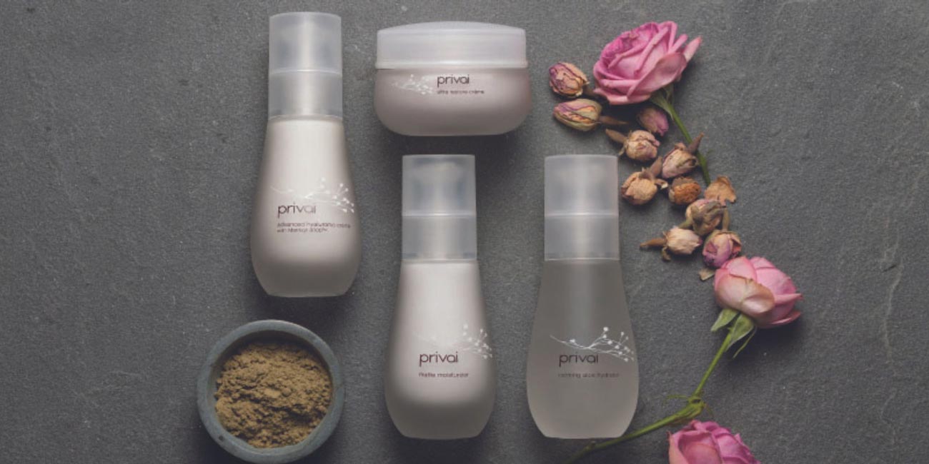 Flat lay of Privai products surrounded by pink roses